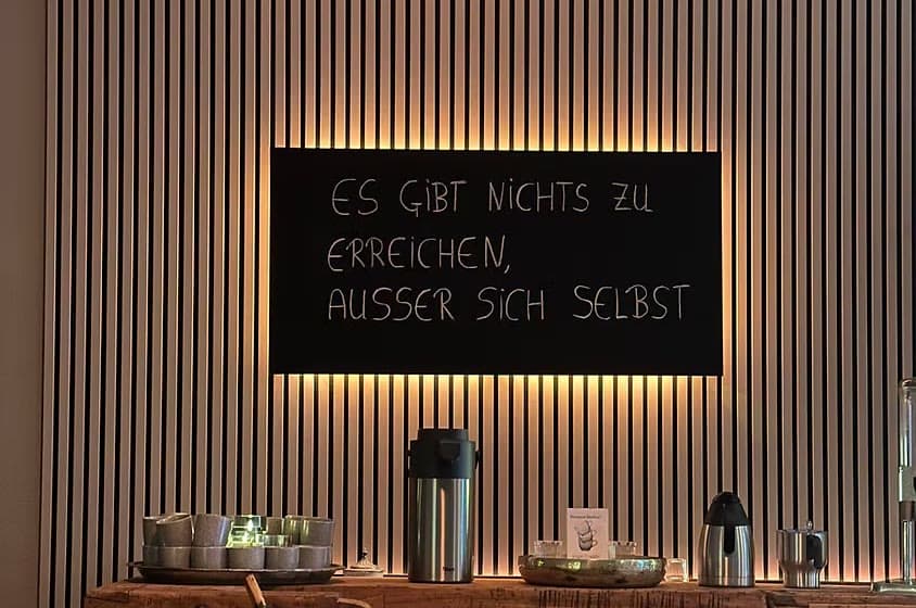 Die Namasté-Lounge im yogawirkt mit beleuchteter Tafel und Teestation