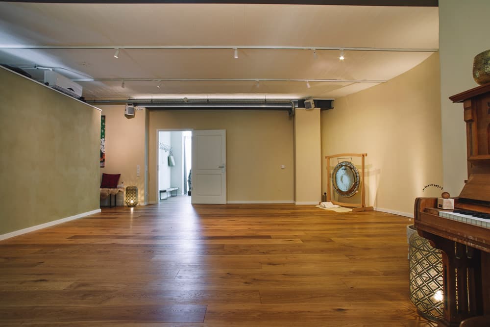Der Kursraum im NIVAS Studio Bielefeld mit Holzboden und Gong